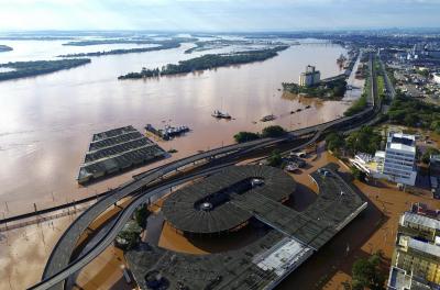 Ajude o Rio Grande do Sul. A imagem mostra uma visão aérea de Porto Alegre, capital gaúcha, inundada