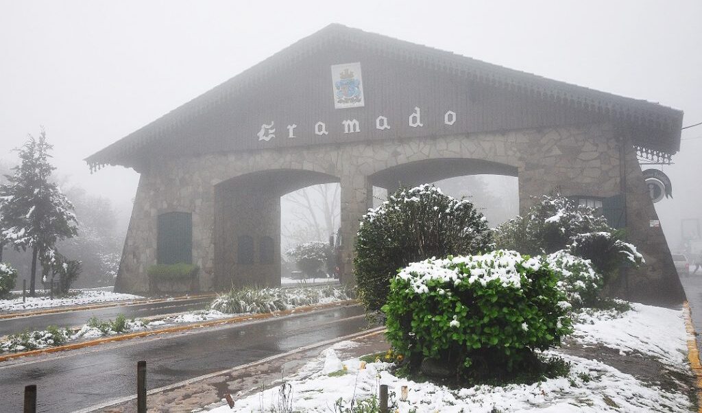 Imagem do pórtico de Gramado coberto por neve.